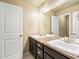 Bathroom with double sink vanity, dark wood cabinets, and a large mirror, offering a clean and modern aesthetic at 15145 W Washburn Ave, Denver, CO 80228