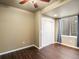 Bedroom with dark wood floors, double door closet, and a window with gray curtains at 15145 W Washburn Ave, Denver, CO 80228