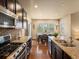 Kitchen and dining area featuring stainless steel appliances, island, and hardwood floors at 15145 W Washburn Ave, Denver, CO 80228