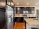 Modern kitchen featuring stainless steel appliances, dark cabinets, granite countertops, and hardwood flooring at 15145 W Washburn Ave, Denver, CO 80228