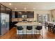 Modern kitchen featuring stainless steel appliances, a granite island with seating, and dark cabinetry at 15145 W Washburn Ave, Denver, CO 80228