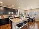 Modern kitchen with dark wood cabinets, granite countertops, an island, and stainless steel appliances at 15145 W Washburn Ave, Denver, CO 80228