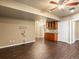 Open living room features dark wood floors and wet bar with dark wood cabinets at 15145 W Washburn Ave, Denver, CO 80228