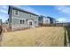 Spacious backyard with lawn, showing the home's siding and stone accents at 20040 E 61St Dr, Aurora, CO 80019