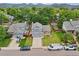 A beautiful aerial view of a light-blue home with an attached garage, a landscaped lawn, and lush trees in the background at 6017 S Pierson St, Littleton, CO 80127