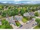 An aerial view captures a home with manicured lawns, mature trees, and the serene view of mountains in the background at 6017 S Pierson St, Littleton, CO 80127