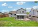 Backyard view featuring a covered patio, lush lawn, and a well-maintained fence at 6017 S Pierson St, Littleton, CO 80127