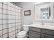 Bathroom with black and white striped shower curtain, framed art, and vanity at 6017 S Pierson St, Littleton, CO 80127