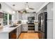 Galley kitchen features gray cabinetry, stainless steel appliances, and hardwood floors at 6017 S Pierson St, Littleton, CO 80127