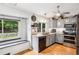 Updated kitchen featuring stainless appliances, gray cabinets, hardwood floors, and a large window at 6017 S Pierson St, Littleton, CO 80127