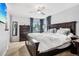 Primary bedroom with a dark wood bed frame, dresser and large windows at 6017 S Pierson St, Littleton, CO 80127