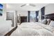 Main bedroom with dark wood bed frame, dresser and window with curtains at 6017 S Pierson St, Littleton, CO 80127