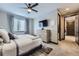 Cozy bedroom with ceiling fan, large window, dresser, and access to ensuite bath at 16345 Spanish Peak Way, Broomfield, CO 80023