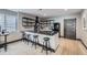Modern kitchen island with granite countertops, bar stools, and sleek black shelving at 16345 Spanish Peak Way, Broomfield, CO 80023