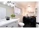 Modern bathroom with black hexagon tiles, gray vanity, and convenient washer-dryer units at 18397 E Alabama Pl # D, Aurora, CO 80017