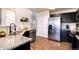 Modern kitchen with stainless steel appliances, granite countertops, and dark wood cabinetry at 18397 E Alabama Pl # D, Aurora, CO 80017