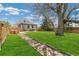 Beautiful backyard with lush lawn, walking path, mature trees, hot tub, and outdoor seating at 2441 E 47Th Ave, Denver, CO 80216