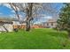 Large backyard featuring a mature tree, manicured lawn, patio, hot tub, and outdoor furniture at 2441 E 47Th Ave, Denver, CO 80216