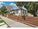 Charming home exterior featuring a low fence, gray stucco, and a welcoming porch at 2441 E 47Th Ave, Denver, CO 80216
