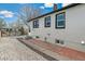 Side view of gray home showcasing a patio, gravel yard, and a modern fence for privacy at 2441 E 47Th Ave, Denver, CO 80216