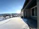 Covered patio overlooking snowy backyard with mountain views at 15454 W Auburn Ave, Lakewood, CO 80228