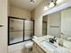 Bathroom features a tile shower, tile floor, and granite countertop and sink, and frosted glass shower door at 15454 W Auburn Ave, Lakewood, CO 80228