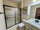 Bathroom features a tile shower, tile floor, and granite countertop and sink, and frosted glass shower door at 15454 W Auburn Ave, Lakewood, CO 80228