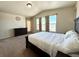 Bright bedroom with large windows, a dark wood bed frame, and neutral-toned walls and carpet at 15454 W Auburn Ave, Lakewood, CO 80228