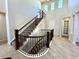 Grand staircase with dark wood and iron detailing, leading to upper floors in a well-lit foyer at 15454 W Auburn Ave, Lakewood, CO 80228