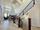 Elegant curved staircase with wooden railing and stone fireplace at 15454 W Auburn Ave, Lakewood, CO 80228