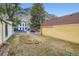 Backyard view of yellow home with grass, trees, and white picket fence at 400 Argentine St, Georgetown, CO 80444
