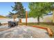 Spacious backyard with stone patio, outdoor dining set, white fence, and mature trees at 400 Argentine St, Georgetown, CO 80444