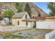 Charming two-story yellow home with a white picket fence and mature trees at 400 Argentine St, Georgetown, CO 80444