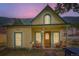 Cozy two-story home with rocking chairs on the porch, complemented by a vivid sunset sky at 400 Argentine St, Georgetown, CO 80444