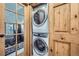 This laundry room features a stacked washer and dryer unit in a space with wooden accents at 400 Argentine St, Georgetown, CO 80444