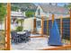Charming patio with stone floor, dark colored patio furniture, wooden privacy fence, and string lights at 400 Argentine St, Georgetown, CO 80444