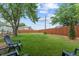 Large backyard with mature trees, a wooden fence, and a sprawling lawn, ideal for outdoor enjoyment at 247 Tipple Pkwy, Frederick, CO 80530