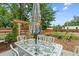 Outdoor dining area in the backyard with a decorative glass table, chairs, and pergola at 247 Tipple Pkwy, Frederick, CO 80530