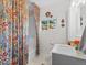 Bright bathroom featuring a shower with a floral curtain, modern vanity, and decorative wall art at 247 Tipple Pkwy, Frederick, CO 80530