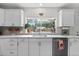 Bright kitchen featuring white cabinets, modern countertops, and a window with garden decor at 247 Tipple Pkwy, Frederick, CO 80530