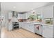 Well-lit kitchen with white cabinets, stainless steel appliances, decorative backsplash, and a large window at 247 Tipple Pkwy, Frederick, CO 80530
