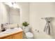 A well-lit half bathroom features a vanity, toilet, and decorative finishes at 7725 Hummingbird Green # 78, Frederick, CO 80530