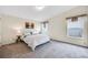 Comfortable bedroom featuring soft carpet, two windows, and a cozy queen sized bed at 7725 Hummingbird Green # 78, Frederick, CO 80530