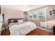 This bedroom has wood floors, a large window, and modern decor at 2564 S Acoma St, Denver, CO 80223