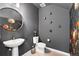 Modern powder room with pedestal sink, toilet, and dark-grey walls at 1415 W 68Th Ave, Denver, CO 80221