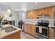 Bright kitchen boasts light wood cabinets and modern appliances, adjacent to a cozy dining area at 8997 W 88Th Ave, Westminster, CO 80021