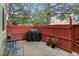 Cozy outdoor patio space with a grill, string lights, and red fencing for privacy at 8997 W 88Th Ave, Westminster, CO 80021