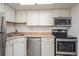 Kitchen features white cabinets and modern stainless steel appliances at 1885 S Quebec Way # A16, Denver, CO 80231