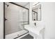 Modern bathroom features a sleek vanity, a black-framed mirror and shower with grey tiled walls at 1412 Pierce St, Lakewood, CO 80214