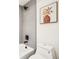 Bright bathroom with tiled walls, shower and white fixtures at 1412 Pierce St, Lakewood, CO 80214